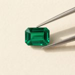 Lab-grown emerald · No. 96 held in tweezers on ivory paper